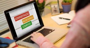 uma mulher consultando um notebook com os dizeres 'administração, secretariado, comércio' na tela e apenas os seus braços mostrados