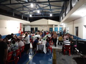 pessoas reunidas para a noite da pizza da apae