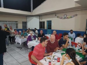 pessoas reunidas para a noite da pizza da apae